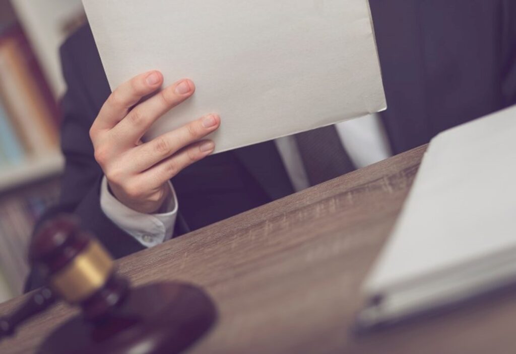 Lawyer sitting at desk with demand letter in hand