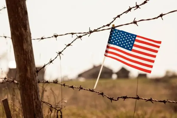 U.S. flag on other side of wire fence