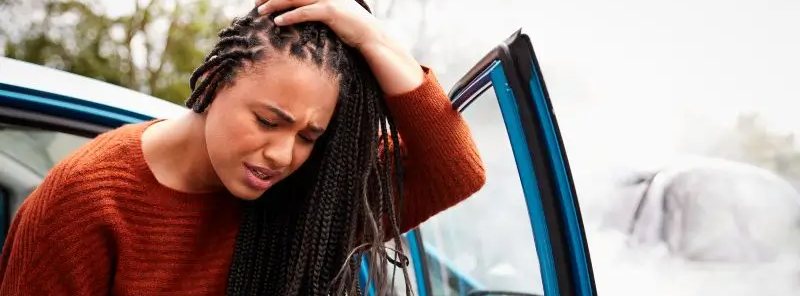 Woman holding her head after car accident