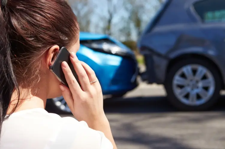 A woman calling her insurance after an accident