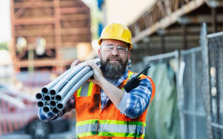 Construction worker carrying materials on jobsite in Houston, TX