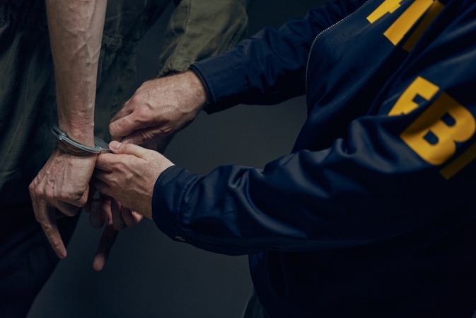 A cop handcuffs a person after being charged with Assault in Houston, TX
