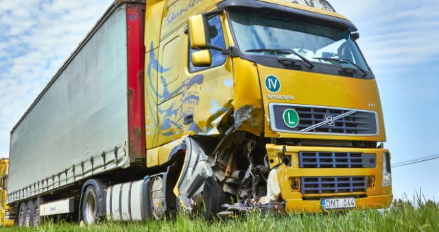 A damaged yellow truck on the roadside after a collision on a Houston, TX highway